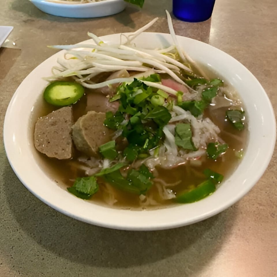 A bowl of Pho 78 Vietnamese pho with meat, noodles, bean sprouts, and herbs.